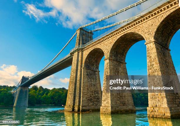 menai suspension bridge, completed in 1826, crossing the menai strait between the island of anglesey and the mainland of wales, united kingdom - menai suspension bridge ストックフォトと画像