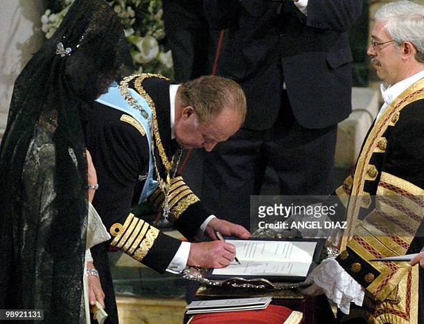Juan Carlos of Spain signs the mariage register next to his wife Queen Sofia at the end of the wedding ceremony of Spanish Crown Prince Felipe of...