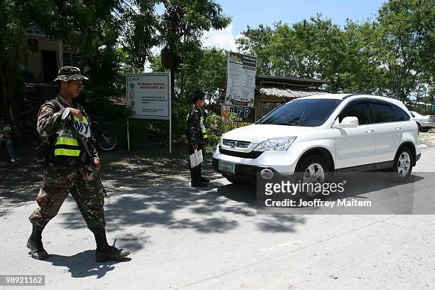 Philippine security forces inspect motorists on May 8, 2010 in Shariff Aguak, Maguindanao Province, Philippines. Shariff Aguak was the location of a...