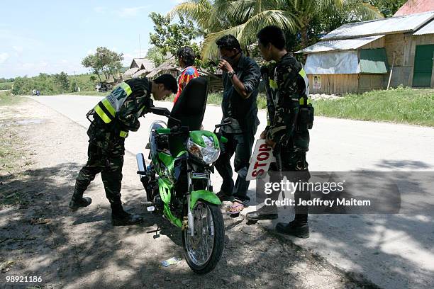 Philippine security forces inspect motorists on May 8, 2010 in Shariff Aguak, Maguindanao Province, Philippines. Shariff Aguak was the location of a...