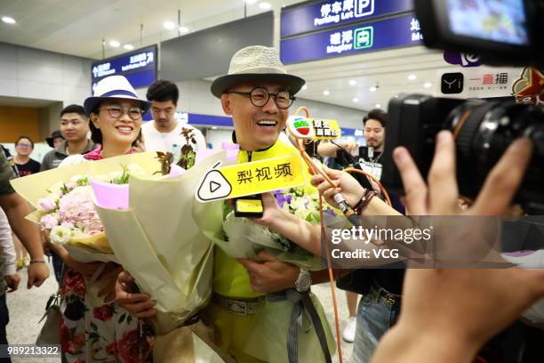 Comedian Zhou Libo and his wife Hu Jie are seen at Shanghai Pudong International Airport after the court dismissed his case on June 30, 2018 in...