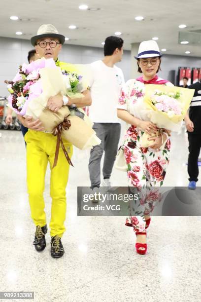 Comedian Zhou Libo and his wife Hu Jie are seen at Shanghai Pudong International Airport after the court dismissed his case on June 30, 2018 in...