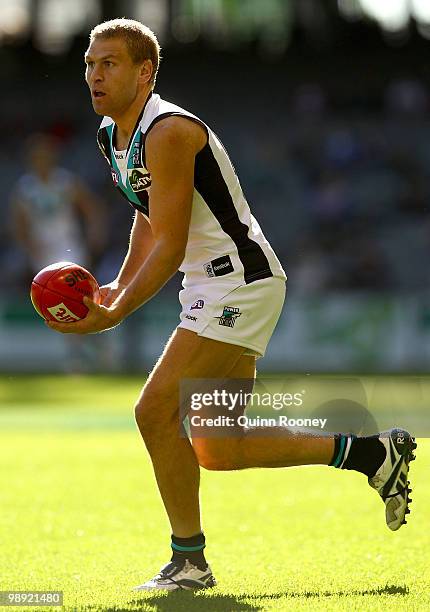 Kane Cornes of the Power handballs during the round seven AFL match between the Essendon Bombers and the Port Adelaide Power at Etihad Stadium on May...