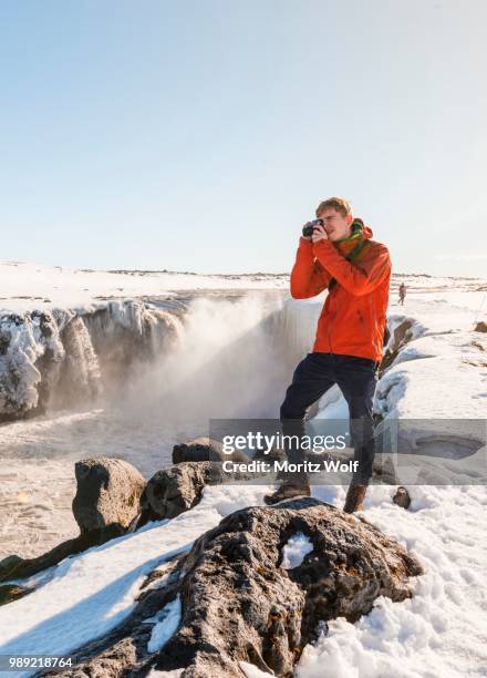 photographing man at selfoss waterfall in winter, gorge, north iceland, iceland - skaftafell national park stock pictures, royalty-free photos & images