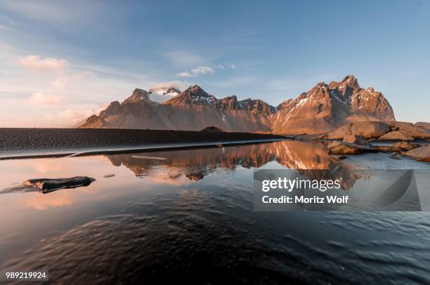 evening atmosphere at the long lava beach, black sand beach, reflection in the water, mountains klifatindur, eystrahorn and kambhorn, headland stokksnes, mountain range klifatindur, austurland, east iceland, iceland - austurland stock pictures, royalty-free photos & images