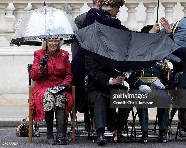 Camilla, Duchess of Cornwall laughs as Bob Ainsworth struggles to put up an umbrella at the VE Day 65th anniverary tributes at the Cenotaph in...