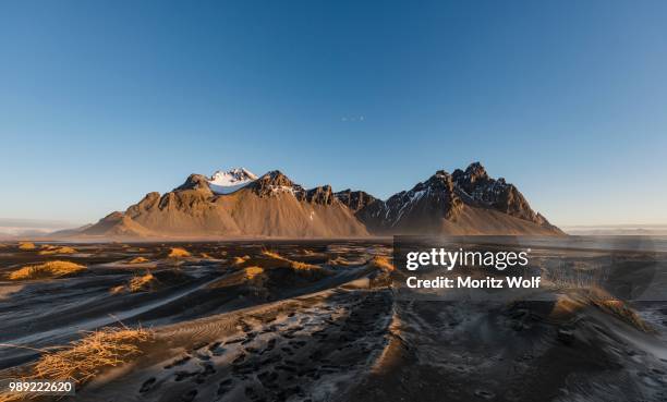 lava beach, black sand beach, overgrown dunes, mountains klifatindur, eystrahorn and kambhorn, headland stokksnes, massif klifatindur, austurland, east iceland, iceland - austurland stock pictures, royalty-free photos & images