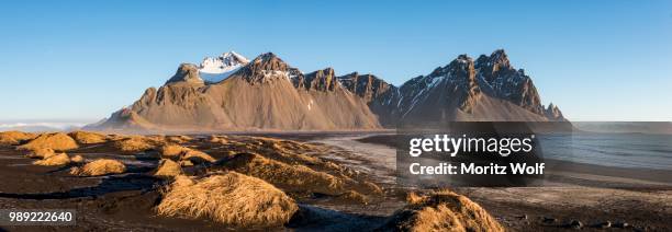 lava beach, black sand beach, overgrown dunes, mountains klifatindur, eystrahorn and kambhorn, headland stokksnes, massif klifatindur, austurland, east iceland, iceland - austurland stock pictures, royalty-free photos & images