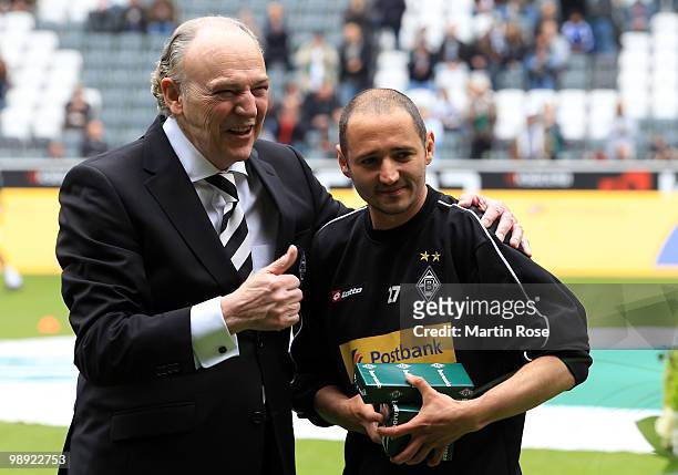 Rolf Koenigs , president of Gladbach hands over a present to Oliver Neuville prior to the Bundesliga match between Borussia Moenchengladbach and...