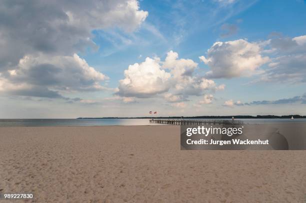 empty sandy beach and pier, cloudy sky, travemuende, baltic sea, schleswig-holstein, germany - travemuende stock pictures, royalty-free photos & images