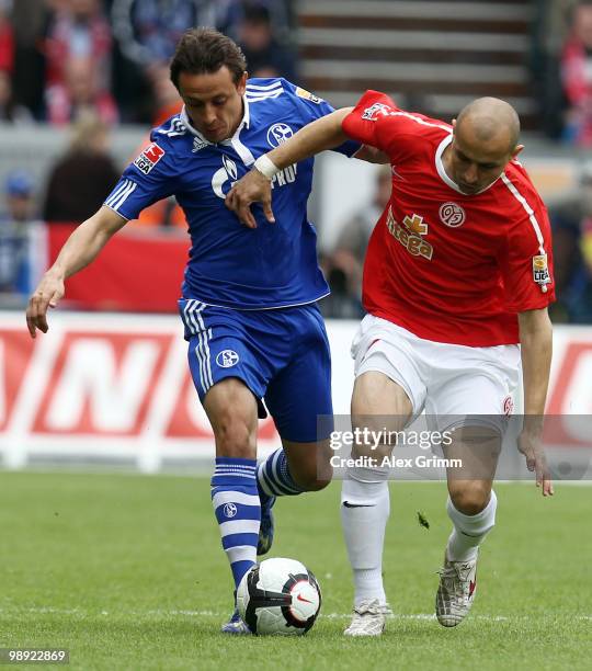 Rafinha of Schalke is challenged by Elkin Soto of Mainz during the Bundesliga match between FSV Mainz 05 and FC Schalke 04 at the Bruchweg Stadium on...