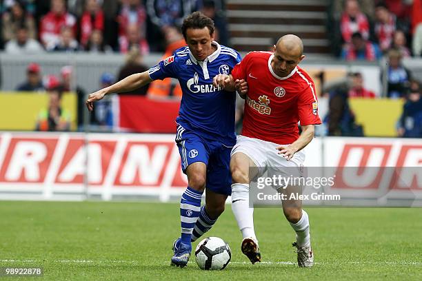 Rafinha of Schalke is challenged by Elkin Soto of Mainz during the Bundesliga match between FSV Mainz 05 and FC Schalke 04 at the Bruchweg Stadium on...