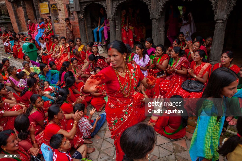 Groep voornamelijk Nepalese vrouwen bekleed met rode traditionele kleding.