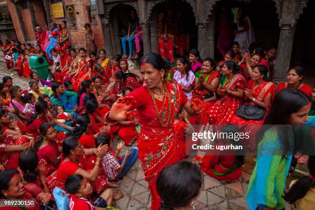 group of mainly nepalese women clad in red traditional clothing. - clad stock pictures, royalty-free photos & images