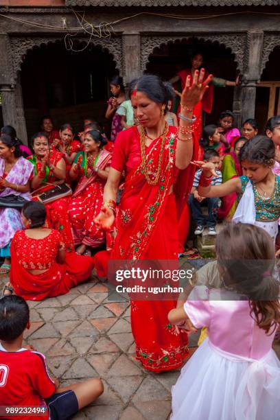 group of mainly nepalese women clad in red traditional clothing. - clad stock pictures, royalty-free photos & images