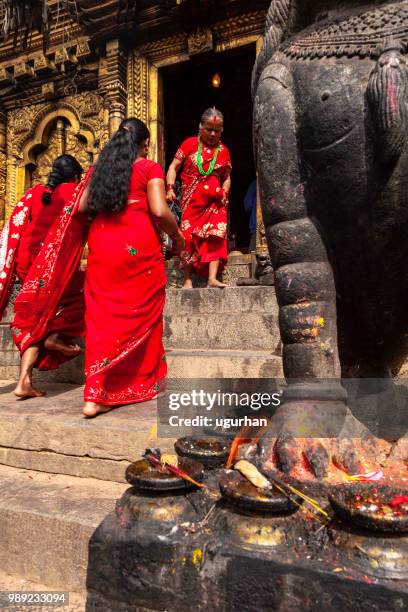 nepalese vrouwen bekleed met rode traditionele kleding in de tempel. - clad stockfoto's en -beelden