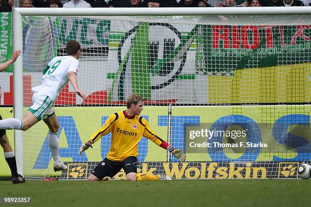 Edin Dzeko of Wolfsburg scores his teams third goal against Ralf Faehrmann of Frankfurt during the Bundesliga match between VfL Wolfsburg and...