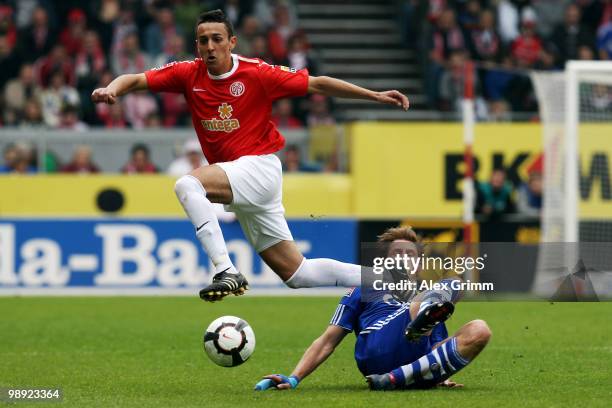 Chadli Amri of Mainz is challenged by Benedikt Hoewedes of Schalke during the Bundesliga match between FSV Mainz 05 and FC Schalke 04 at the Bruchweg...