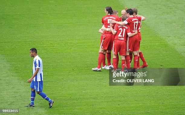 Hertha Berlin's Brazilian striker Raffael walks past Bayern Munich's players celebrating Croatian striker Ivica Olic's goal during the German first...