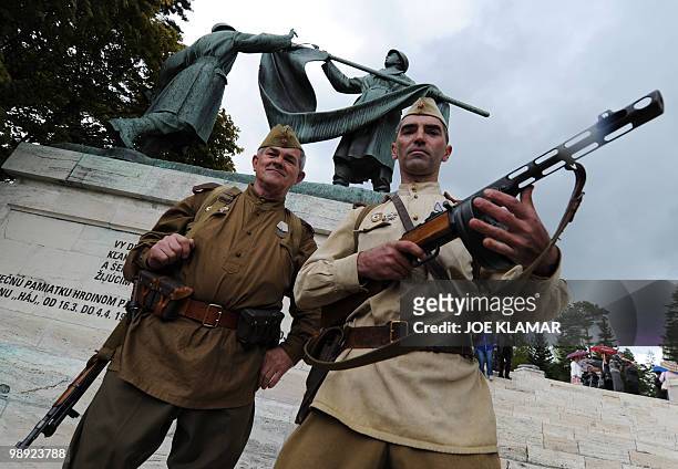 Members of the Slovak historical military club, Tiger, dressed as Soviet liberators, pose at a World War II memorial on May 8, 2010 after...