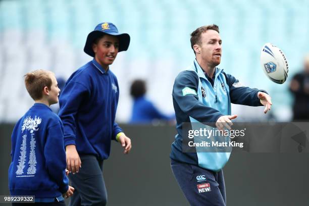 James Maloney takes part in a juniors coaching clinic during the New South Wales Blues State of Origin Team Announcement at ANZ Stadium on July 2,...