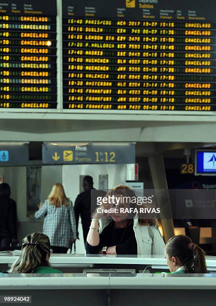 Passenger wait at the information point in front of a departure board displaying cancelled flights at Bilbao's airport in Loiu, northern Spain, on...