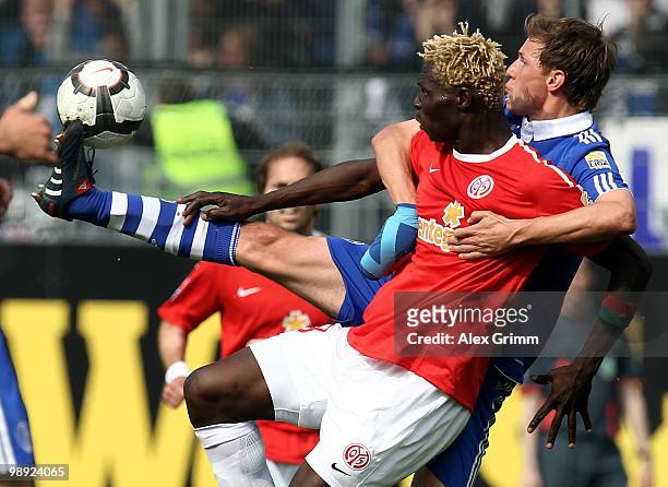 Aristide Bance of Mainz is challenged by Benedikt Hoewedes of Schalke during the Bundesliga match between FSV Mainz 05 and FC Schalke 04 at the...