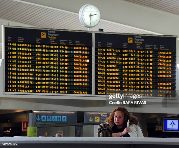 Passenger waits at the information point in front of a departure board displaying cancelled flights at Bilbao's airport in Loiu, northern Spain, on...