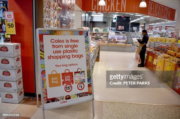 Sign, seen in a Coles supermarket, advises its customers of its plastic bag free in Sydney on July 2, 2018. - One irate customer put his hands round...