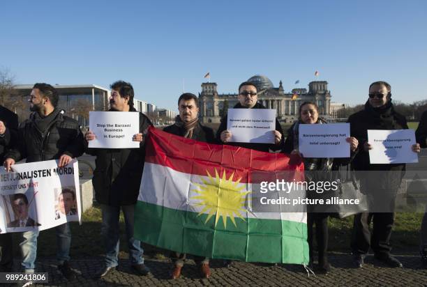 People hold banners and the flag of Kurdistan during a protest against the meeting of Prime Minister of the Kurdistan Regional Government of Iraqi...