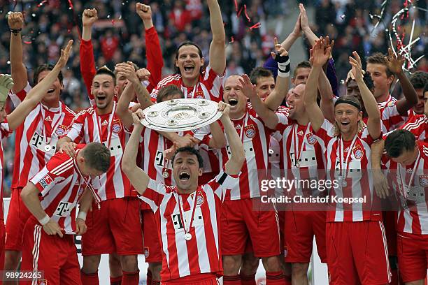 Mark van Bommel of Bayern lifts the German Championship trophy on the podium after the Bundesliga match between Hertha BSC Berlin and FC Bayern...