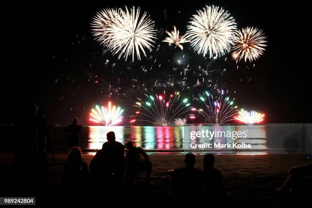 People sit on the beach to watch the fireworks display during Territory Day celebrations at Mindil Beach on July 1, 2018 in Darwin, Australia. Every...