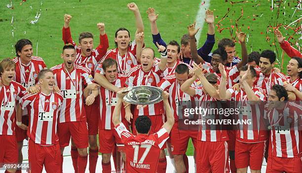 Bayern Munich's Dutch midfielder Mark van Bommel raises the trophy as his teammates celebrate after during the German first division Bundesliga...