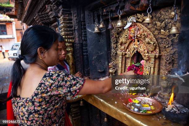 nepalese woman clad in traditional clothing in temple. - clad stock pictures, royalty-free photos & images