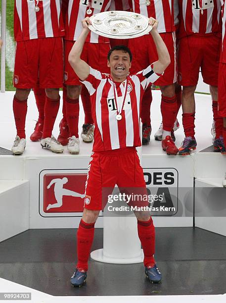 Mark van Bommel of Muenchen lifts the championship trophy after the Bundesliga match between Hertha BSC Berlin and FC Bayern Muenchen at Olympic...