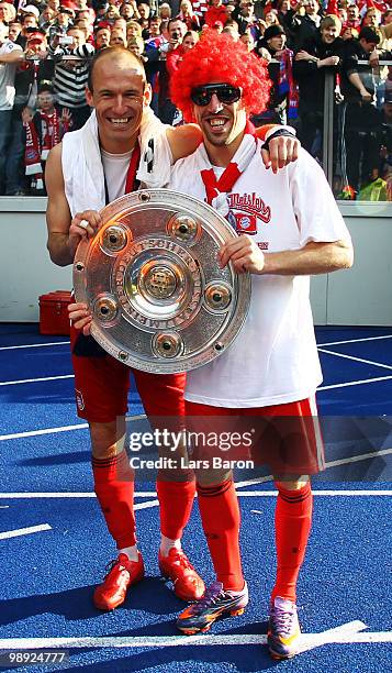 Arjen Robben and team mate Franck Ribery pose with the trophy after the Bundesliga match between Hertha BSC Berlin and FC Bayern Muenchen at Olympic...