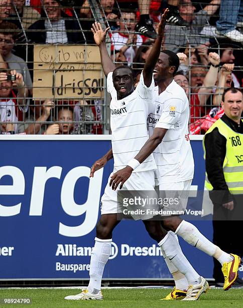 Papiss Cisse of Freiburg celebrates scoring the third goal with Mohamadou Idrissou during the Bundesliga match between SC Freiburg and Borussia...