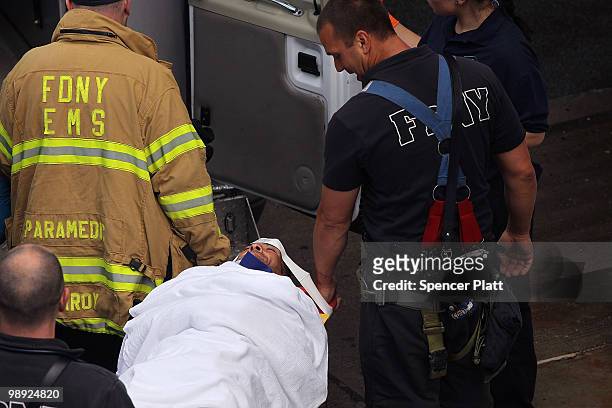 Firefighters and emergency personnel place an injured man in an ambulance following the crash of the Staten Island Ferry into a dock in the city's...