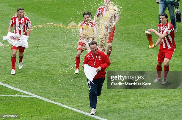 Head coach Louis van Gaal of Bayern receives a beer shower of Danijel Pranjic after the Bundesliga match between Hertha BSC Berlin and FC Bayern...