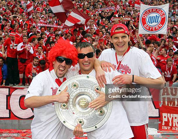 Franck Ribery, Ivica Olic and Daniel van Buyten of Bayern present the German Championship trophy after winning 3-1 the Bundesliga match between...