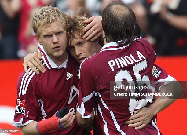 Nuremberg's midfielder Andreas Ottl celebrates scoring with Nuremberg's defender Andreas Wolf and Nuremberg's Argentinian defender Javier Pinola...