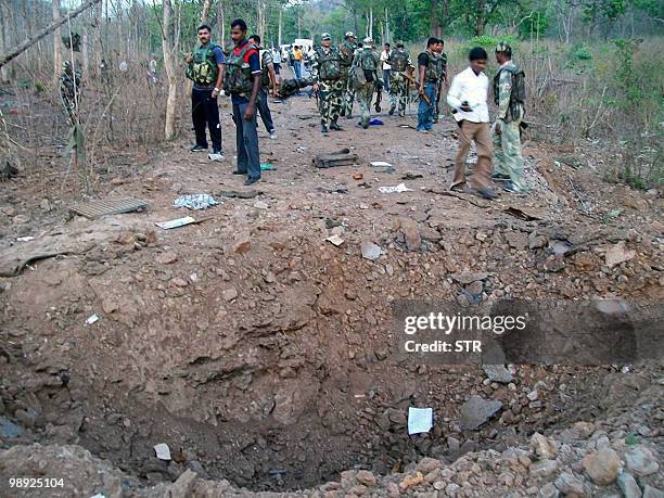 Indian security personnel are seen near a crater, caused by a landmine blast which killed six, in Pedakodepal in Bijapur district, some 550...