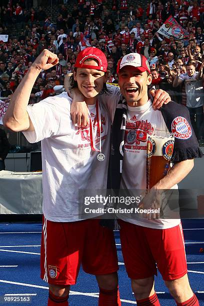 Daniel van Buyten and Mark van Bommel of Bayern celebrate winning the German Champions trophy after winning 3-1 the Bundesliga match between Hertha...