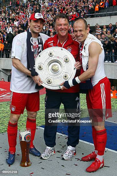 Mark van Bommel, head coach Louis van Gaal and Arjen Robben of Bayern present the German championship trophy during the Bundesliga match between...