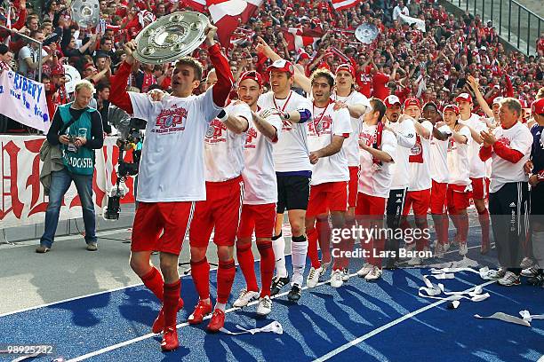 Thomas Mueller of Muenchen lifts the trophy and celebrates with his team mates after the Bundesliga match between Hertha BSC Berlin and FC Bayern...