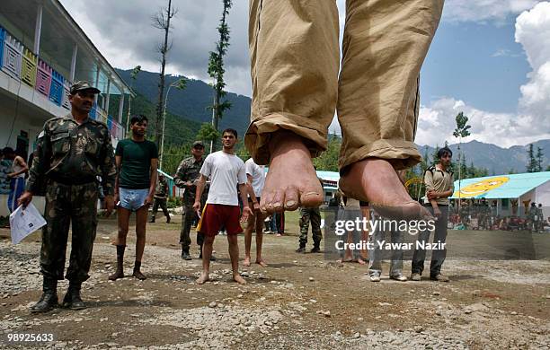 Kashmir youth take push-ups as an Indian army officer look towards himd during a recruitment rally on May 08, 2010 near Pakistan border in Wayin, 100...