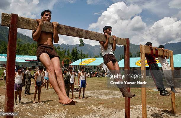 Kashmir youth do pull-ups during a recruitment rally on May 08, 2010 near Pakistan border in Wayin, 100 Kms north of Srinagar, the summer capital of...