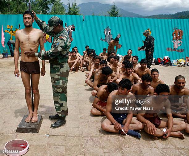 An Indian army officer measures height and weight of a Kashmiri youth during a recruitment rally on May 08, 2010 near Pakistan border in Wayin, 100...