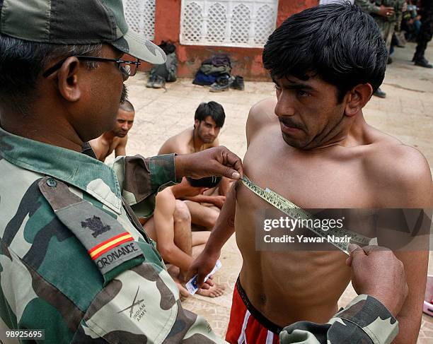 An Indian army officer measures the chest of a Kashmiri youth during a recruitment rally on May 08, 2010 near Pakistan border in Wayin, 100 Kms north...