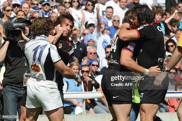 Toulouse's fly-half Byron Keleher celebrates with winger Vincent Clerc while Toulouse's fullback Maxime Medard fights with Castre's Marc Andreu at...